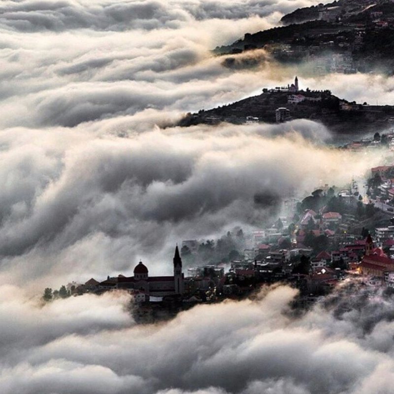 My hometown Bsharri  and kadisha valley hidden by fog only showing the churches